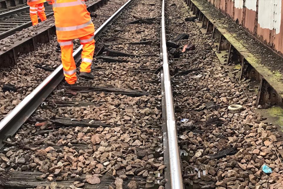 Orange hi-vis suited engineers inspect rail damage at Walthamstow
