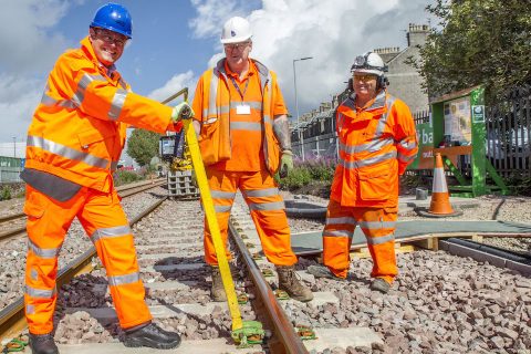 Track workers in orange suits at work near Aberdeen