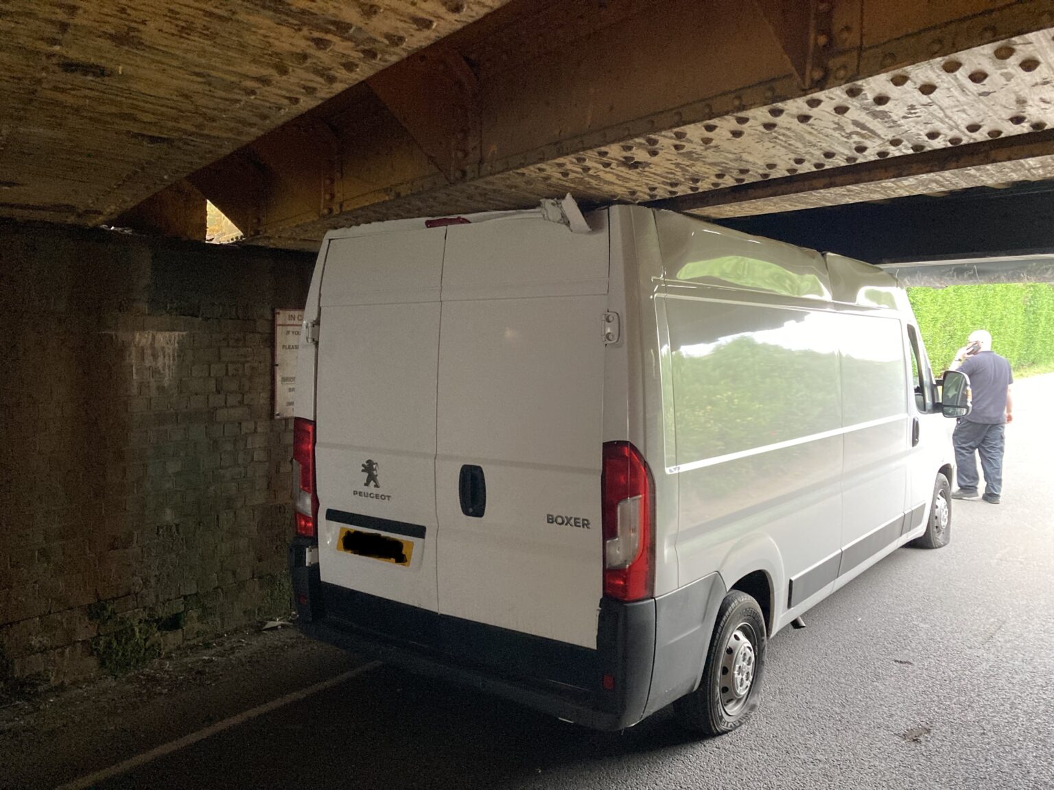 White van jammed under railway bridge