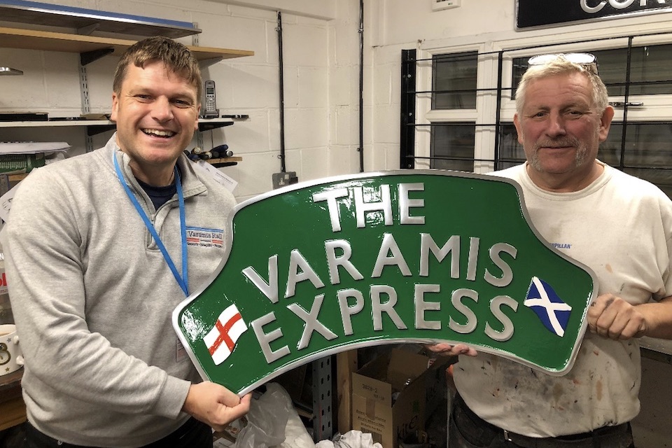 Varamis Express nameplate held up by Phil Read the company owner and staff member