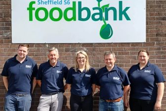 Volunteers from VolkerRail pose outside Sheffield Food Banks warehouse with logo