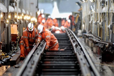Orange suited engineers work on railway tracks