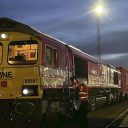 Night time image of container train hauled by "ONE" liveried locomotive