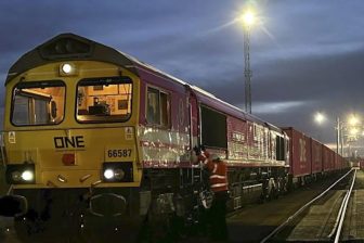 Night time image of container train hauled by "ONE" liveried locomotive