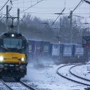A class 88 belonging to Direct Rail Services at speed in the snow hauling a container train