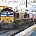 Freight and passenger trains pass each other at Edinburgh Waverley station