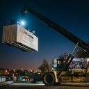 Night time shot of reach stakes moving XPO liveried container