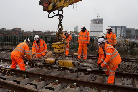 Engineers in orange suits install rails at Reading