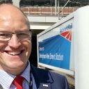 Portrait of Tim Shoveller, the new CEO of Freightliner UK and Europe, in front of a station sign on the platform at Birmingham New Street