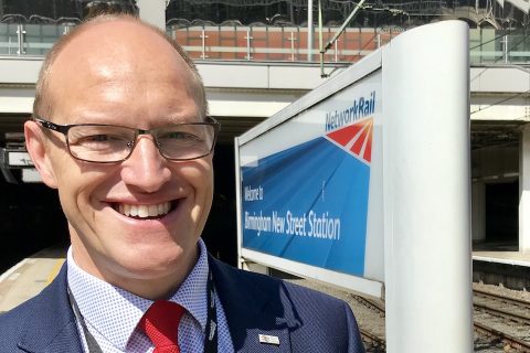 Portrait of Tim Shoveller, the new CEO of Freightliner UK and Europe, in front of a station sign on the platform at Birmingham New Street