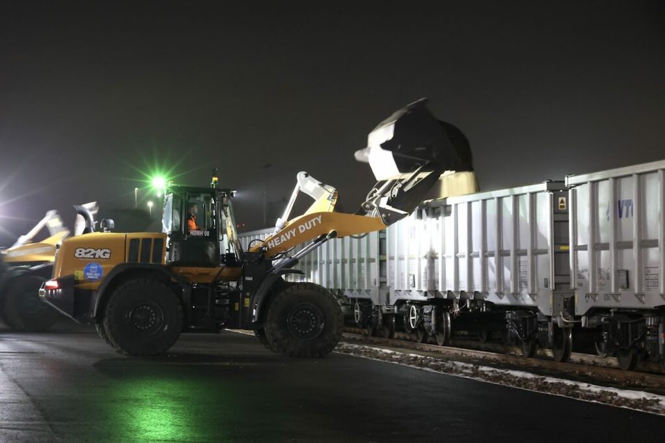 Night time operations as mechanical shovels load freight wagons at Barking Renwick Road waste depot for Biffa