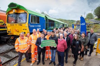 A party of about twenty people at Tunstead Quarry pose in front of several freight locomotives