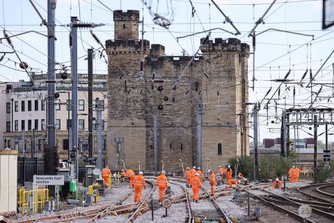 looking down the tracks at the castle in Newcastle with engineers on the line