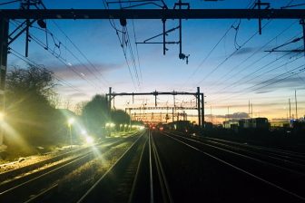 Dawn over railway tracks with engineering floodlights
