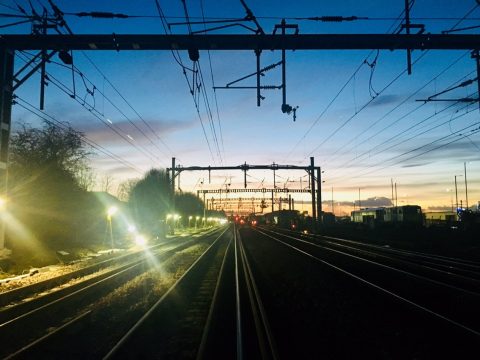 Dawn over railway tracks with engineering floodlights