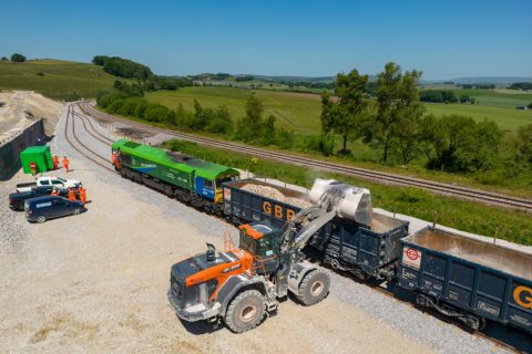 Overhead shot of a mechanical shovel (a digger) loading an aggregate train at Hillhead, a countryside location in Derbyshire