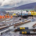 Engineers busy over track layout in a rural setting with the Pennines in the background