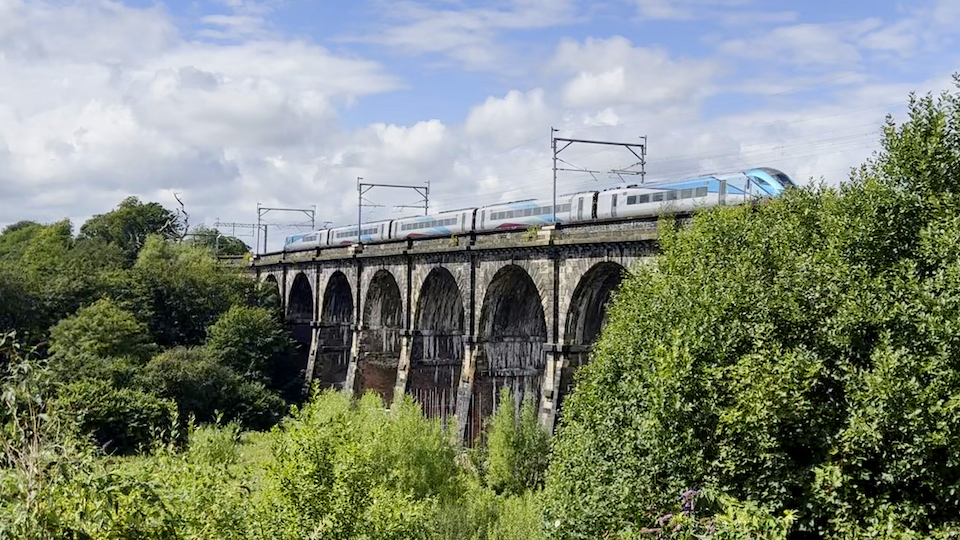 Sankey Viaduct seen from the mid distance with a passenger train crossing