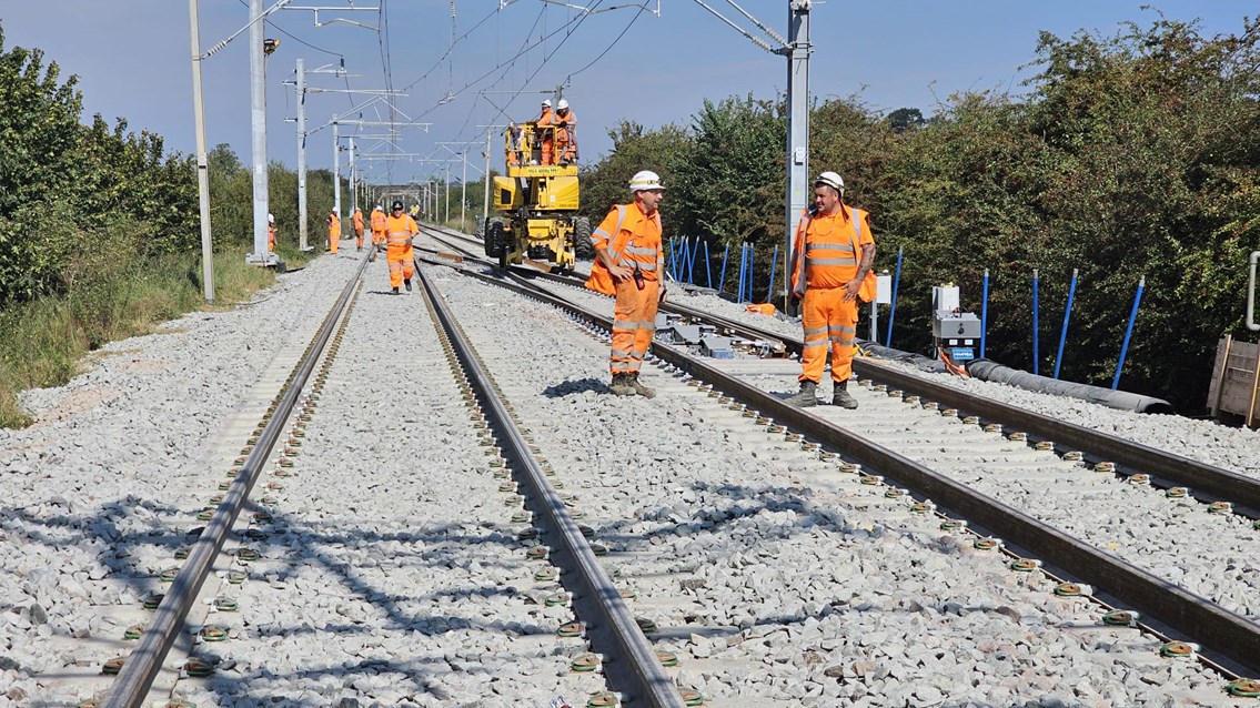 Orange suited engineers on the tracks at Northampton, installing a crossing for the new logistics park there