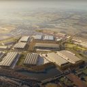 CGI of aerial view of West Midlands Interchange showing warehouses in foreground and countryside behind